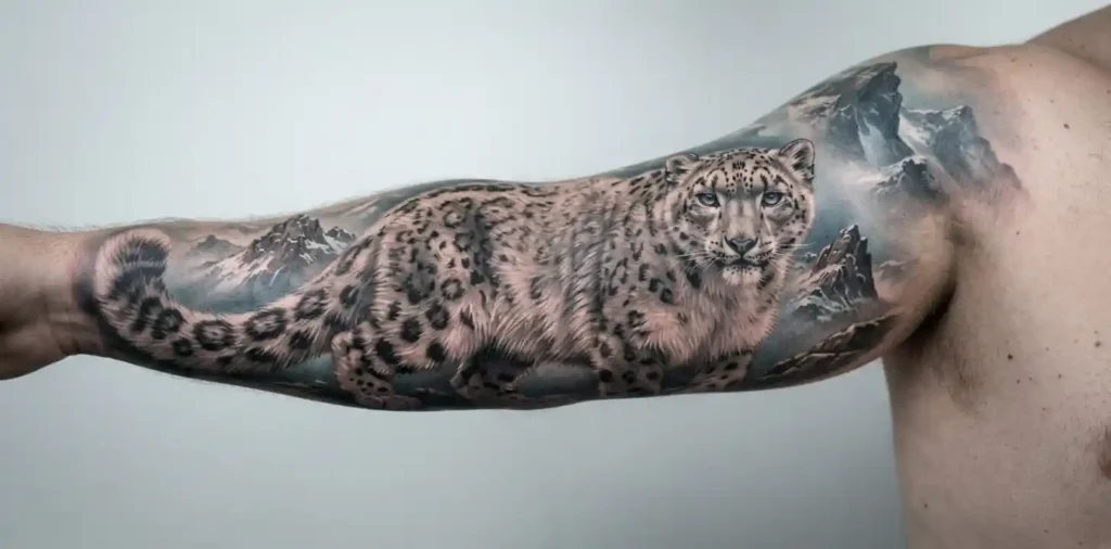 Snow leopard tattoo with mountain landscape details